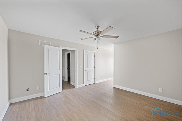 spare room featuring light wood-type flooring and ceiling fan