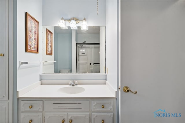 bathroom with walk in shower, vanity, and toilet