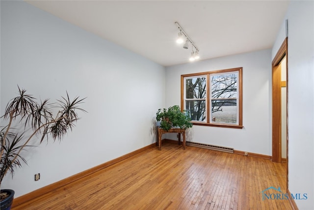 spare room featuring a baseboard radiator and light hardwood / wood-style flooring