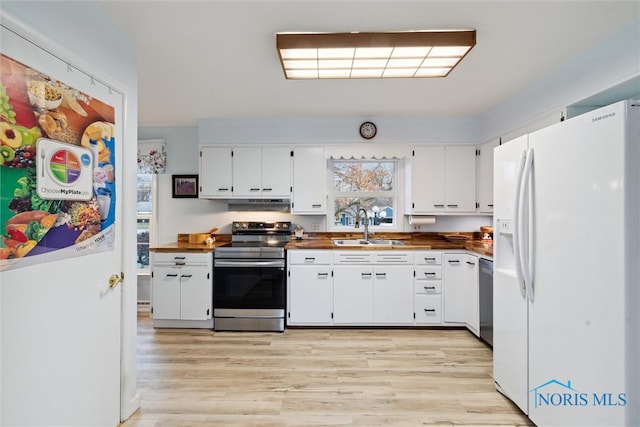 kitchen with appliances with stainless steel finishes, light hardwood / wood-style floors, white cabinetry, and sink