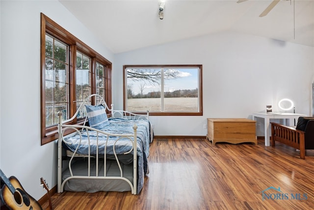 bedroom with hardwood / wood-style flooring, ceiling fan, vaulted ceiling, and multiple windows