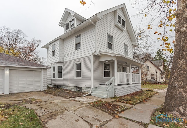 view of front of home with covered porch, a garage, and an outbuilding