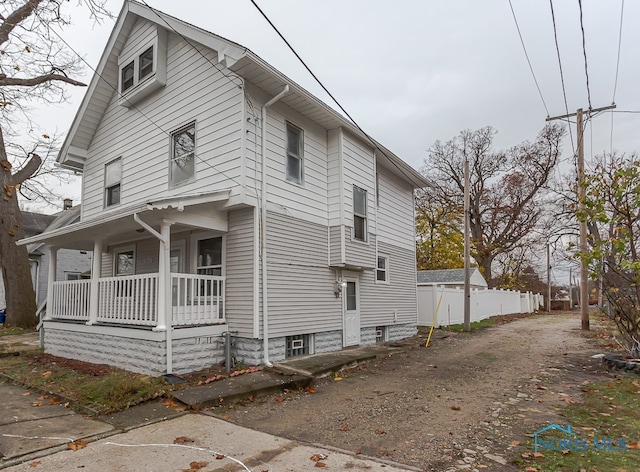 view of side of home featuring covered porch