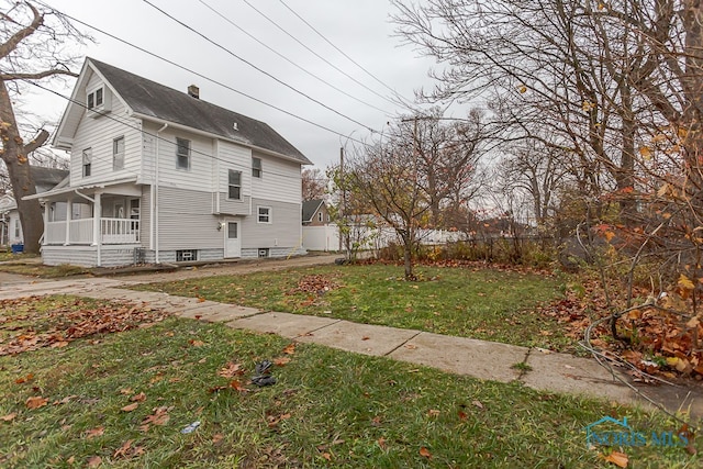 view of home's exterior featuring a porch and a yard