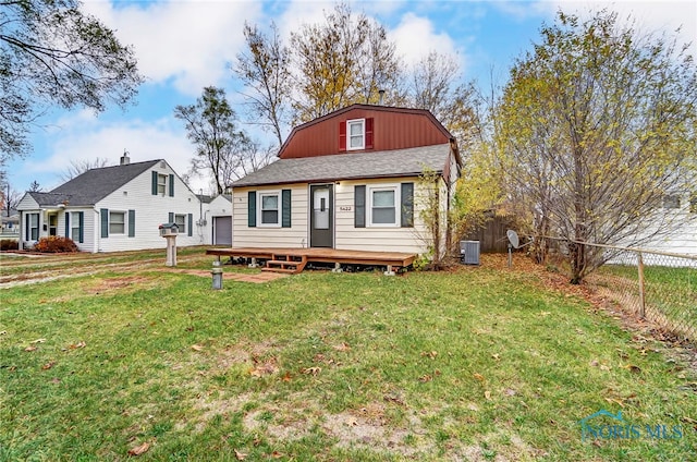 rear view of property featuring a yard, a deck, and cooling unit