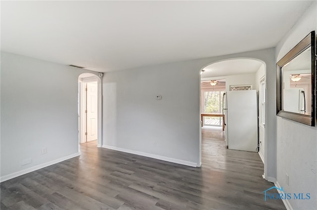 spare room with ceiling fan and dark hardwood / wood-style floors