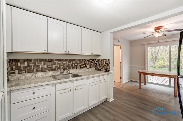 kitchen with dark wood-type flooring, sink, decorative backsplash, ceiling fan, and white cabinetry