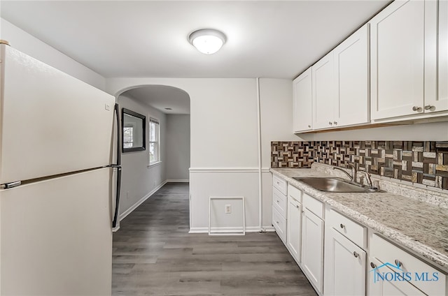 kitchen with white cabinets, white refrigerator, and sink