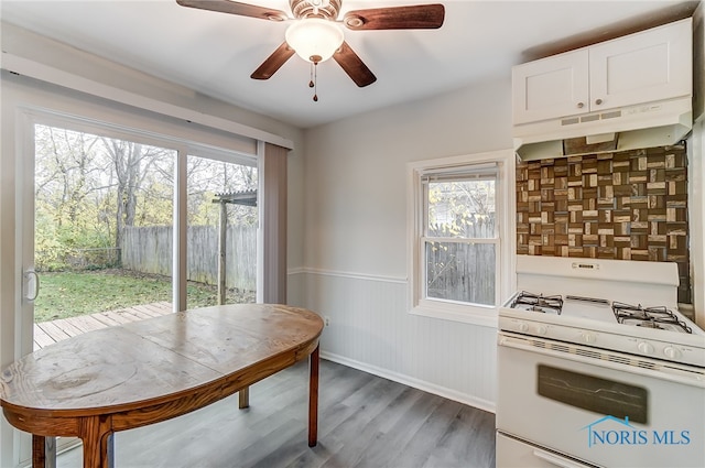 kitchen featuring hardwood / wood-style flooring, ceiling fan, white cabinetry, and white gas range