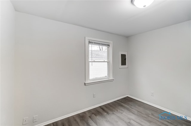 spare room featuring dark hardwood / wood-style floors and electric panel