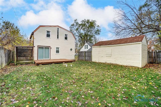 back of property featuring a lawn, a shed, and a wooden deck