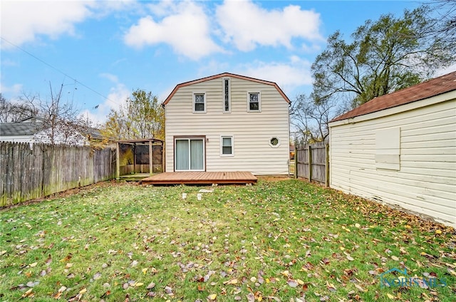 back of property with a yard and a wooden deck