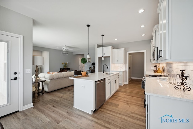 3343 Moonlit Pass, Monclova, OH 43542 - kitchen with sink, an island with sink, decorative light fixtures, white cabinetry, and stainless steel appliances