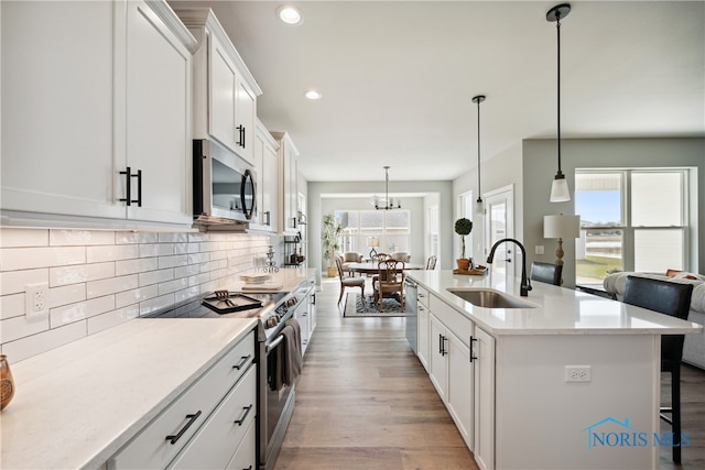 3343 Moonlit Pass, Monclova, OH 43542 - kitchen with white cabinets, stainless steel appliances, hanging light fixtures, and sink