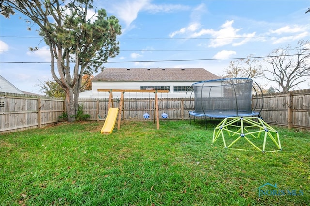 view of yard with a playground and a trampoline