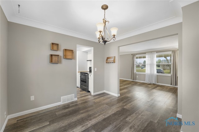 unfurnished dining area featuring dark hardwood / wood-style floors, ornamental molding, a fireplace, and a chandelier