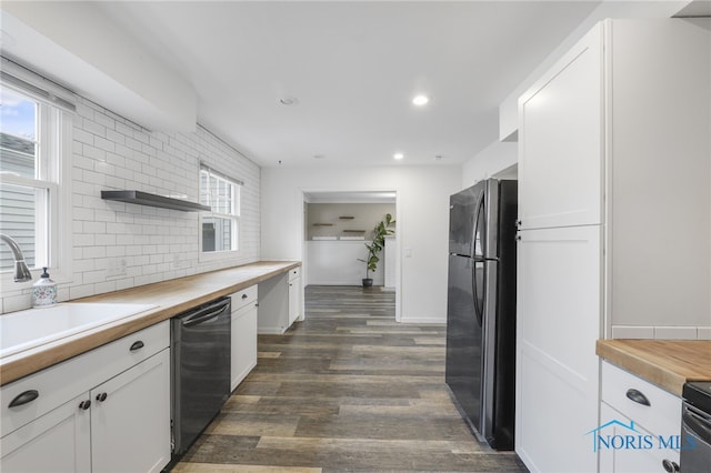 kitchen featuring wooden counters, dark hardwood / wood-style flooring, tasteful backsplash, black appliances, and white cabinets