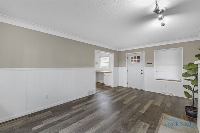 entrance foyer with a textured ceiling, crown molding, and dark wood-type flooring