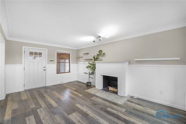 unfurnished living room featuring a fireplace, dark wood-type flooring, and ornamental molding