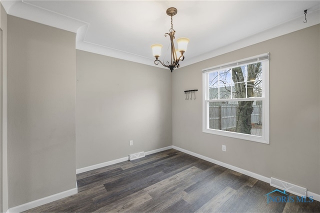 spare room with a chandelier, dark hardwood / wood-style flooring, and crown molding