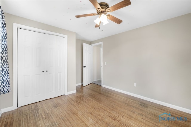 unfurnished bedroom with ceiling fan, a closet, and light wood-type flooring