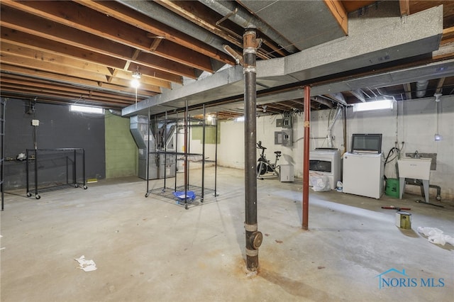 basement with washer / dryer, electric panel, heating unit, and sink