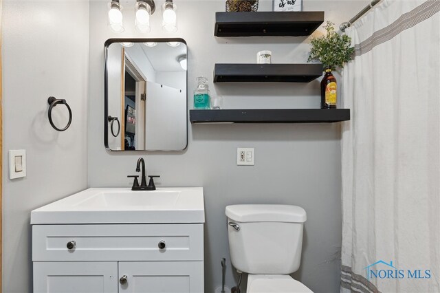 bathroom with a shower with curtain, vanity, and toilet