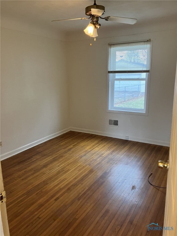 empty room with ceiling fan and dark hardwood / wood-style floors