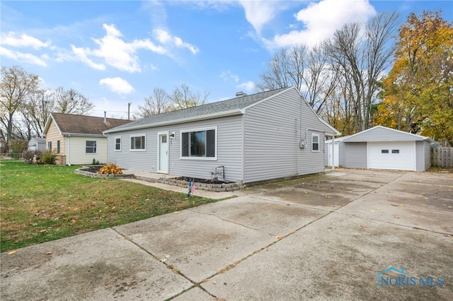 view of front facade featuring a garage, an outbuilding, and a front yard