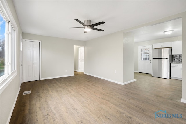 unfurnished living room featuring ceiling fan and light hardwood / wood-style flooring