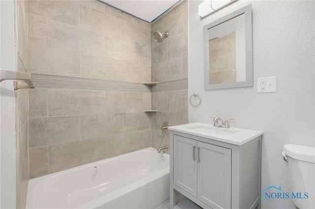 full bathroom with vanity, tiled shower / bath combo, and toilet