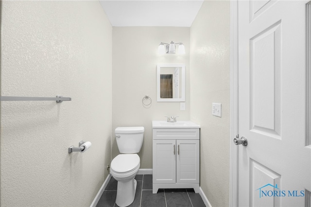 bathroom featuring tile patterned flooring, vanity, and toilet