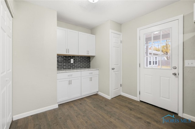 interior space featuring white cabinets, decorative backsplash, and dark hardwood / wood-style floors