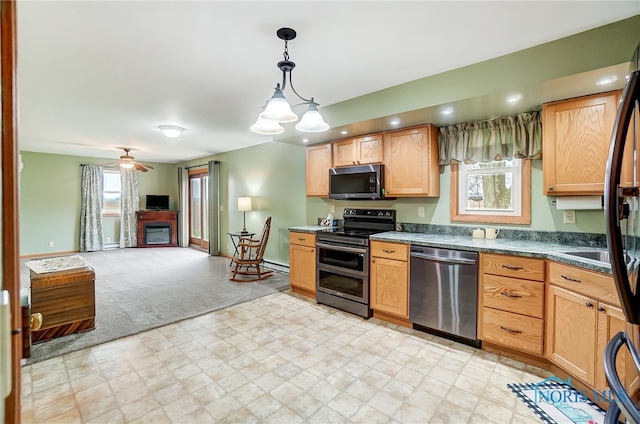 kitchen featuring a wealth of natural light, ceiling fan with notable chandelier, stainless steel appliances, and decorative light fixtures