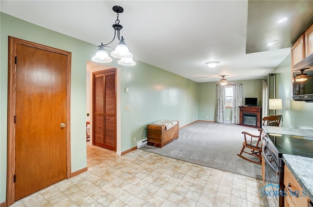 kitchen featuring electric range, ceiling fan with notable chandelier, pendant lighting, and light carpet