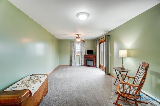 living area with carpet and ceiling fan