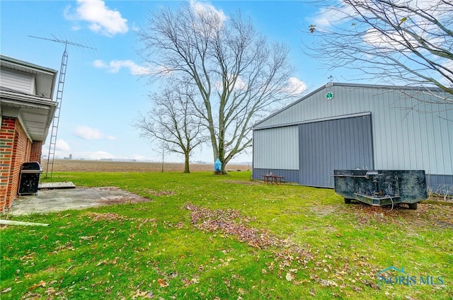 view of yard with an outbuilding and a rural view