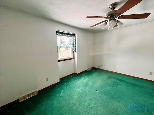 empty room with dark carpet and ceiling fan