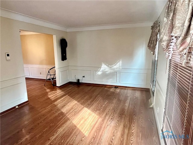 empty room featuring crown molding and wood-type flooring