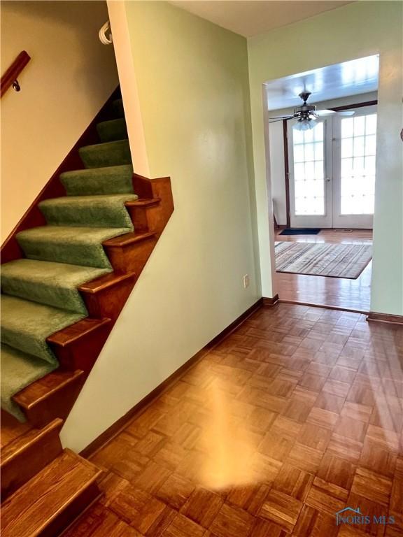 staircase with parquet floors, french doors, and ceiling fan