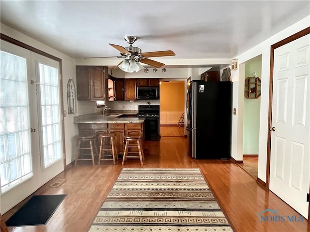 kitchen featuring sink, dark wood-type flooring, a breakfast bar, and appliances with stainless steel finishes