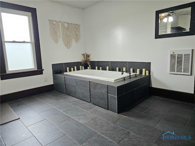 bathroom featuring heating unit and tiled tub