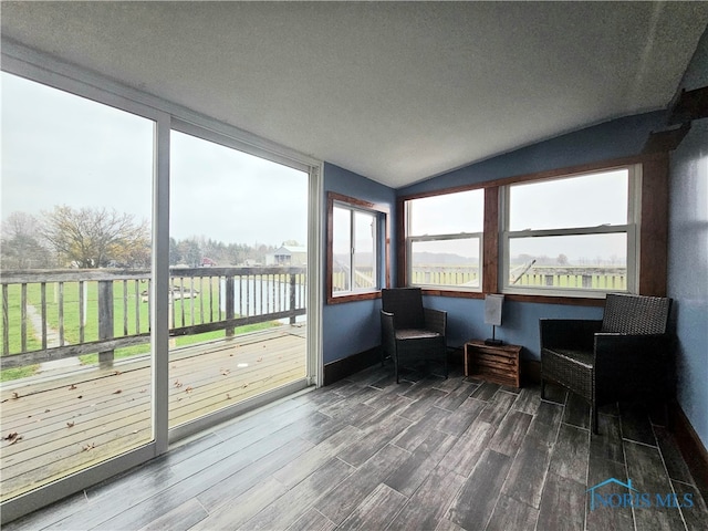 sunroom / solarium featuring a water view and lofted ceiling