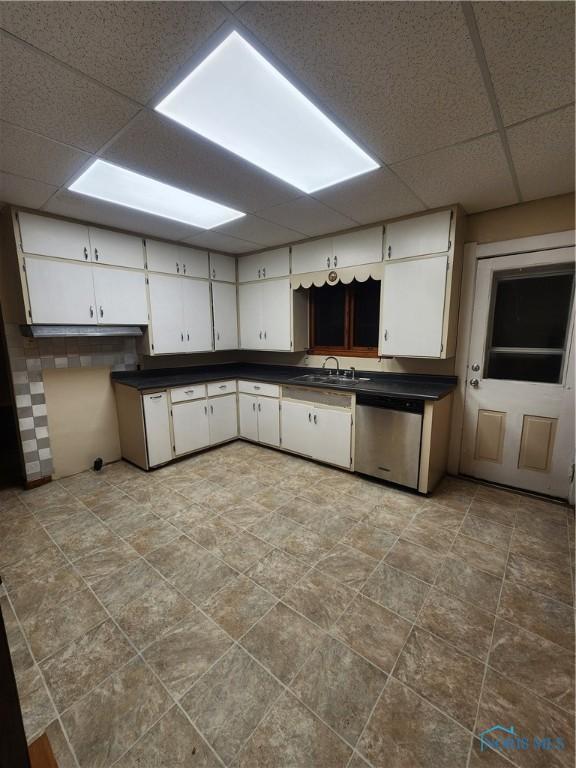 kitchen featuring sink, white cabinets, stainless steel dishwasher, and a drop ceiling