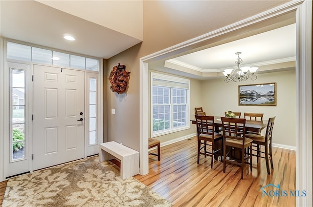 entryway featuring a chandelier, light hardwood / wood-style floors, and ornamental molding