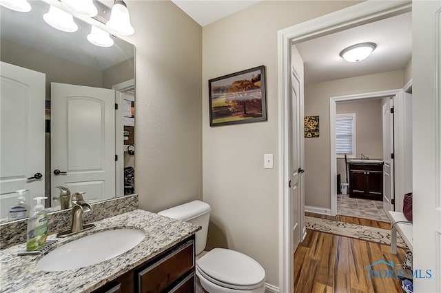 bathroom featuring vanity, hardwood / wood-style flooring, and toilet