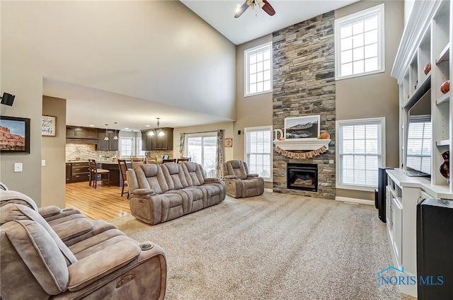 living room featuring light carpet, a towering ceiling, and a healthy amount of sunlight