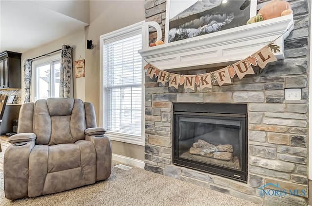 living area with a fireplace and carpet floors