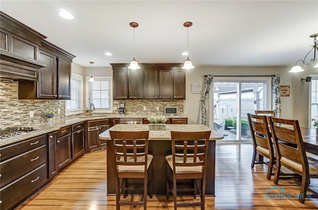 kitchen featuring decorative light fixtures, a healthy amount of sunlight, and a kitchen island