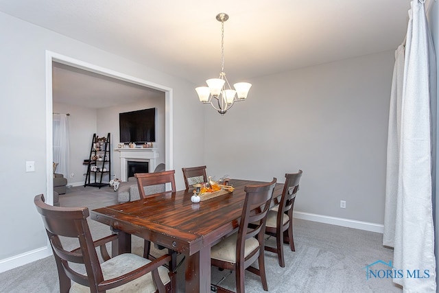 dining room featuring carpet floors and a chandelier